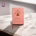 Pink leather notebook engraved with a floral yoga design