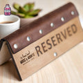 Folded wooden reserved table sign with leather and metal details
