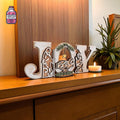 Freestanding wooden JOY Christmas decoration on a shelf