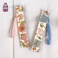 Two clear resin bookmarks with pressed flowers, gold flakes and pink and blue tassels
