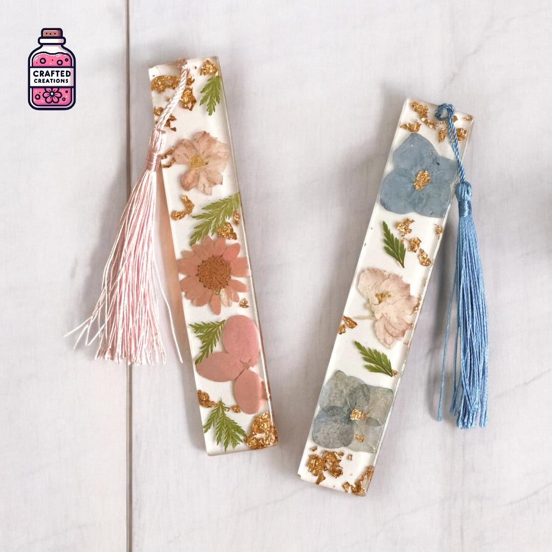 Two clear resin bookmarks with pressed flowers, gold flakes and pink and blue tassels