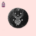 Round black slate Christmas coaster engraved with a reindeer design