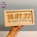 Framed wood and resin keepsake showing a date and names