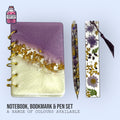Purple and white resin notebook shown with matching pen and floral bookmark