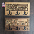 Two wooden dog lead hangers with paw design and metal hooks