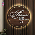 Large round wooden bar sign with raised lettering and decorative border